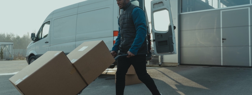 Guy moving boxes on a dolly