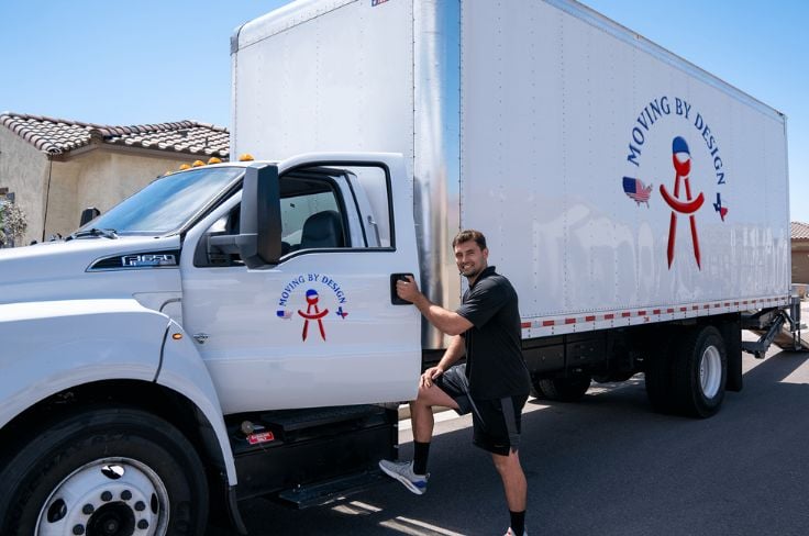 a member of Moving By Design entering a truck