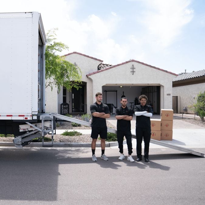 3 members of Moving By Design in front of the truck
