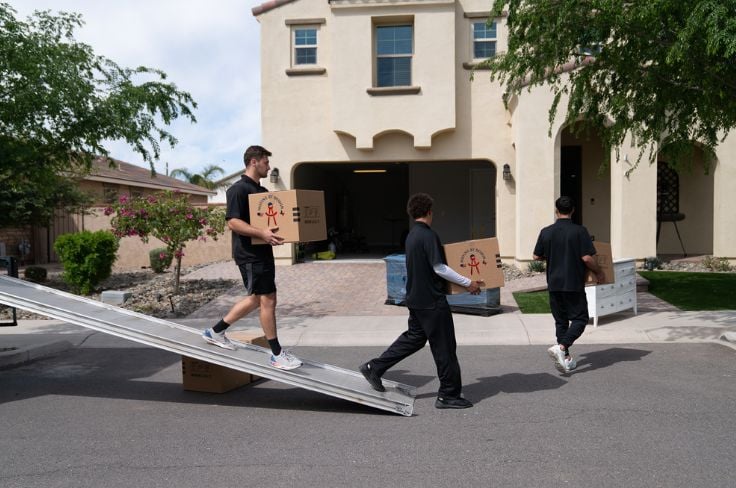 3 members of Moving By Design unloading items from a truck