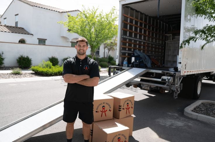 a member of Moving By Design in front of the moving truck